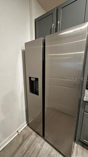 A stainless steel Samsung side-by-side refrigerator is positioned next to dark gray kitchen cabinets — 710 STONEY POINT CIRCLE, DAVENPORT, FL