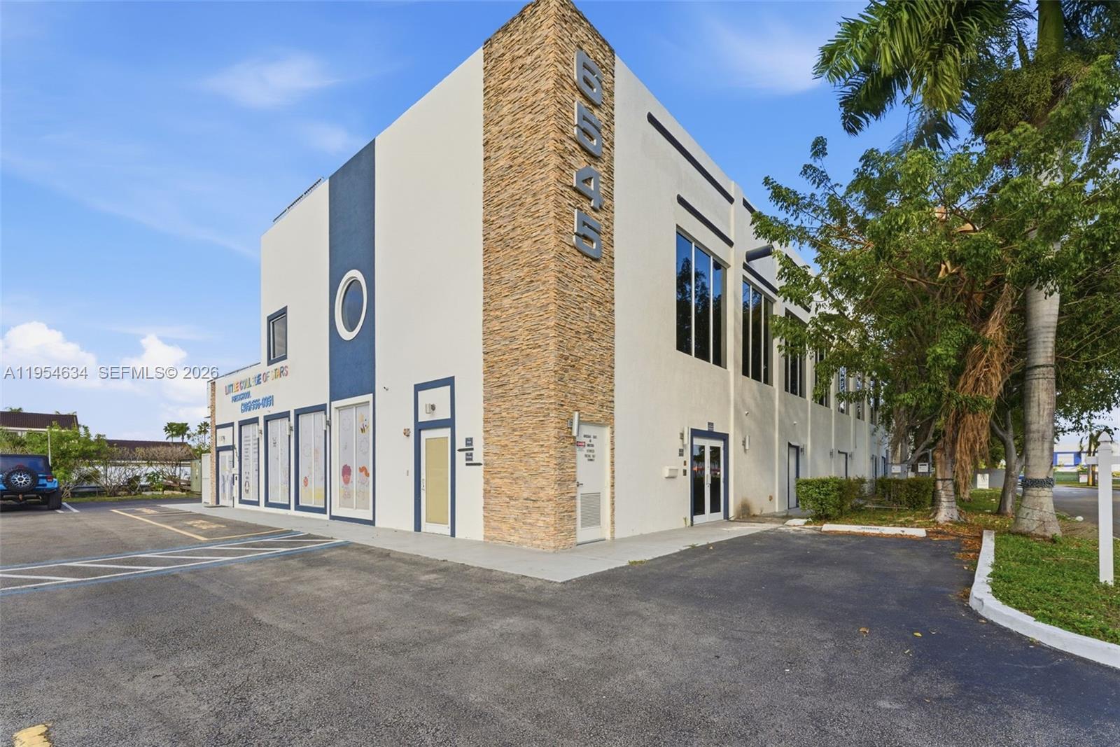 A two-story commercial building with a stone corner facade and a paved parking lot — 6545 NW 169th St, Hialeah FL 33015, HIALEAH, FL