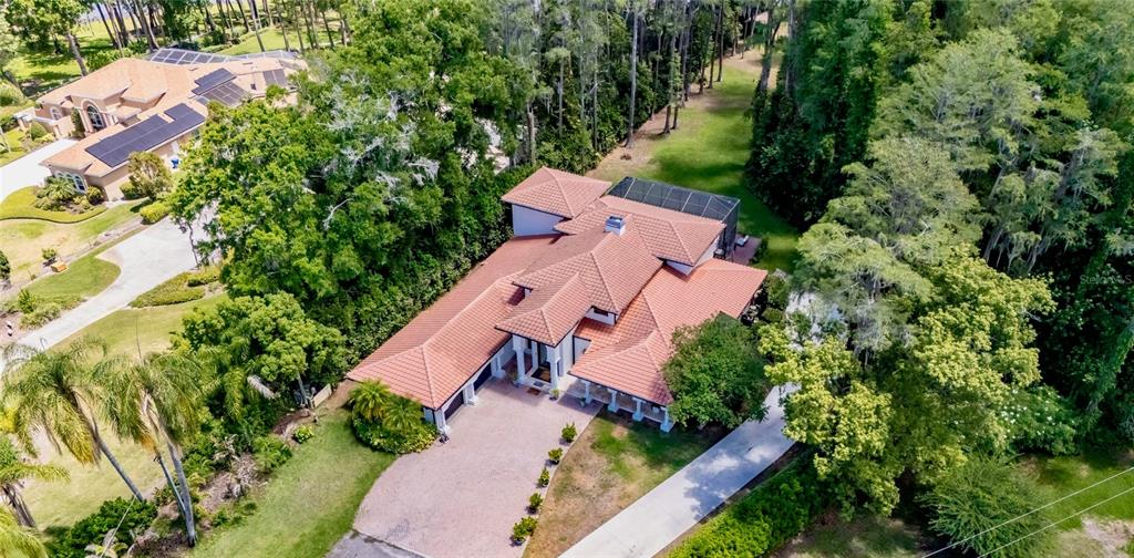 An aerial view shows a large house with a terracotta tile roof and a pool — 17309 LINDA VISTA CIRCLE, LUTZ, FL