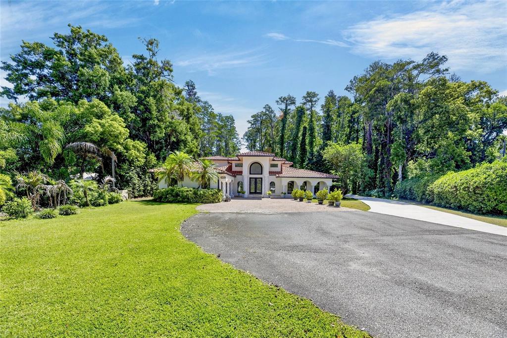 A single-story house with a tiled roof and arched entryway sits at the end of a driveway — 17309 LINDA VISTA CIRCLE, LUTZ, FL