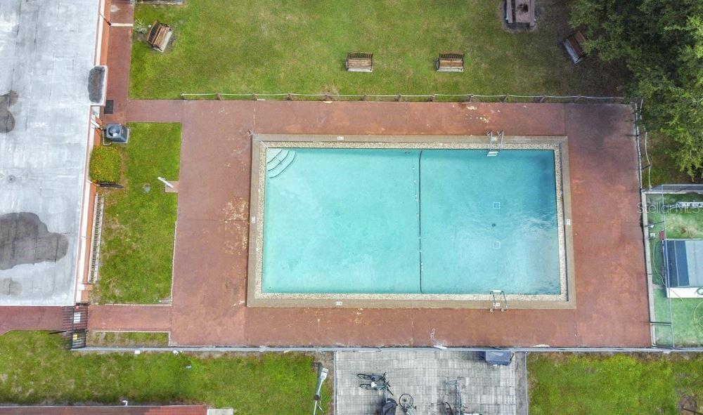 An aerial view shows a rectangular swimming pool surrounded by a brown concrete deck — 719 WYMAN COURT UNIT 719 B, ORLANDO, FL