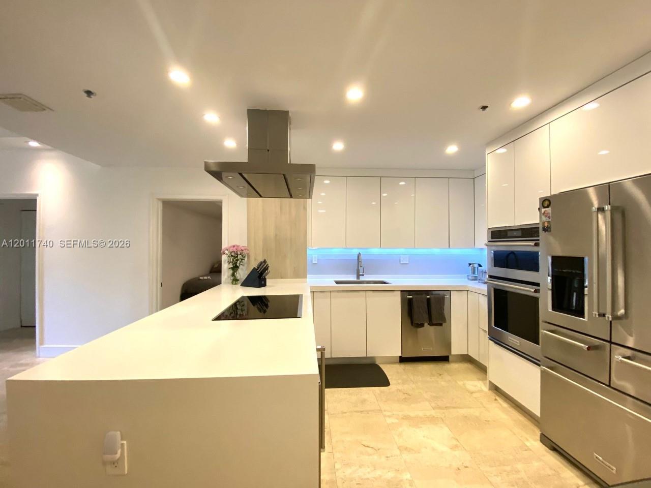 A modern kitchen features white cabinetry, stainless steel appliances, and a large central island — 251 Crandon Blvd # 139, Key Biscayne FL 33149, KEY BISCAYNE, FL