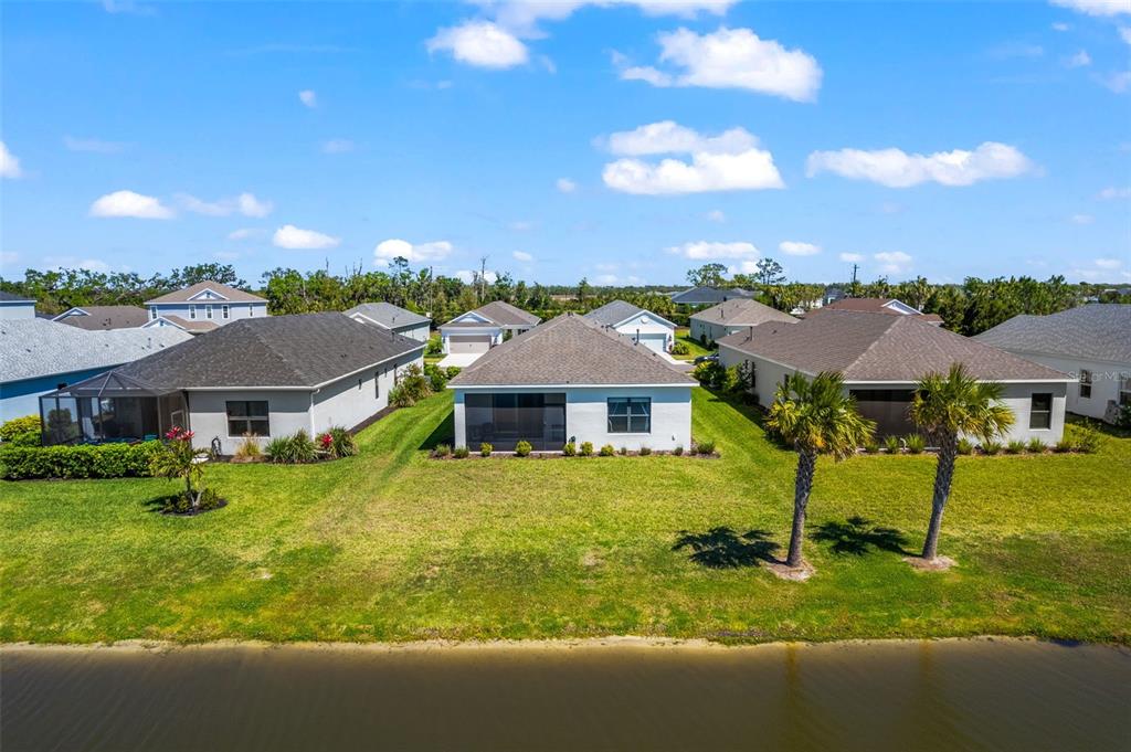 An aerial view of the back of three suburban houses facing a pond — 14147 CAMPFIRE COURT, PARRISH, FL