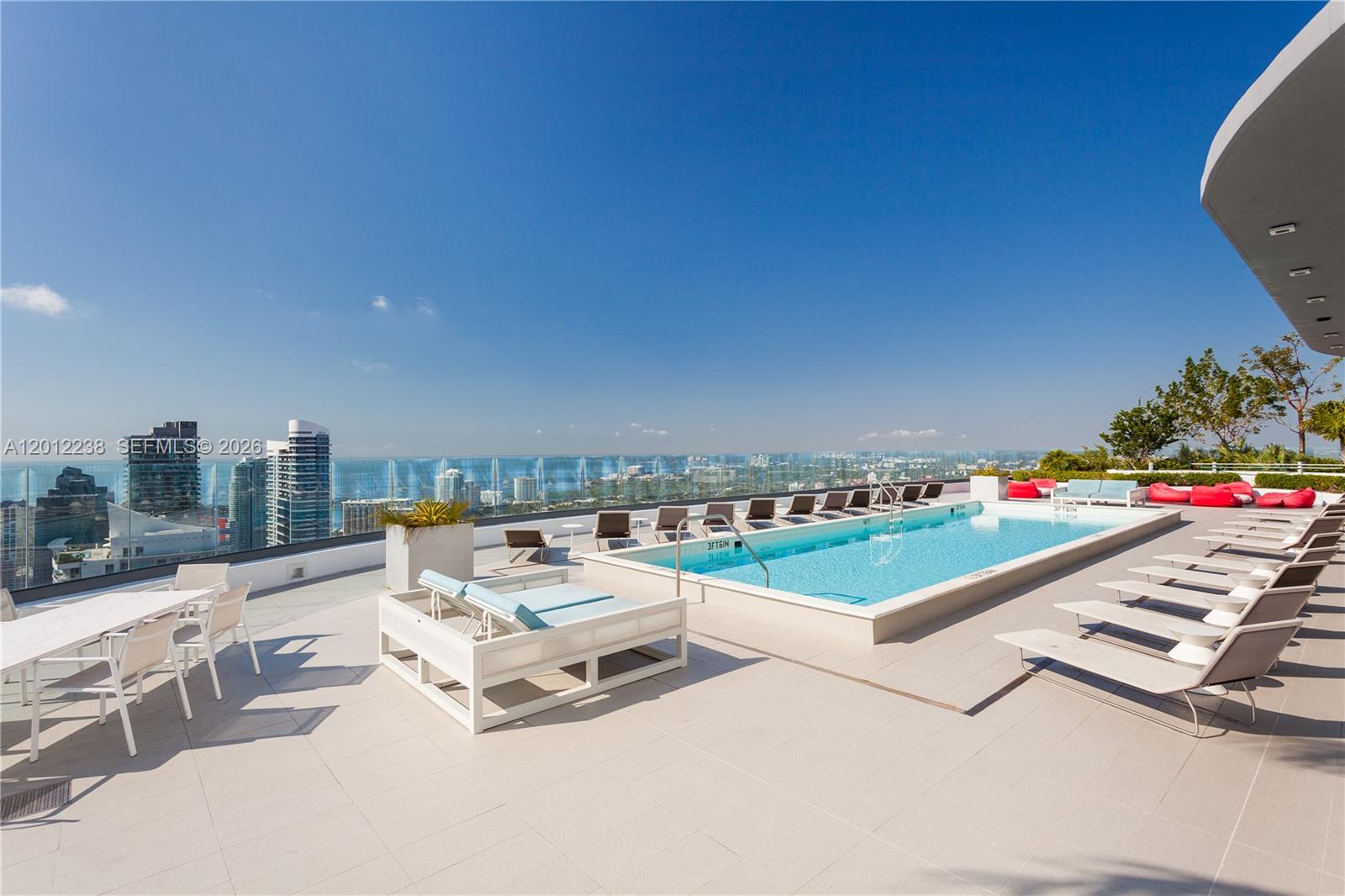 A rooftop terrace features a swimming pool, lounge chairs, and a panoramic city skyline view — 45 SW 9th St # 1604, Miami FL 33130, MIAMI, FL