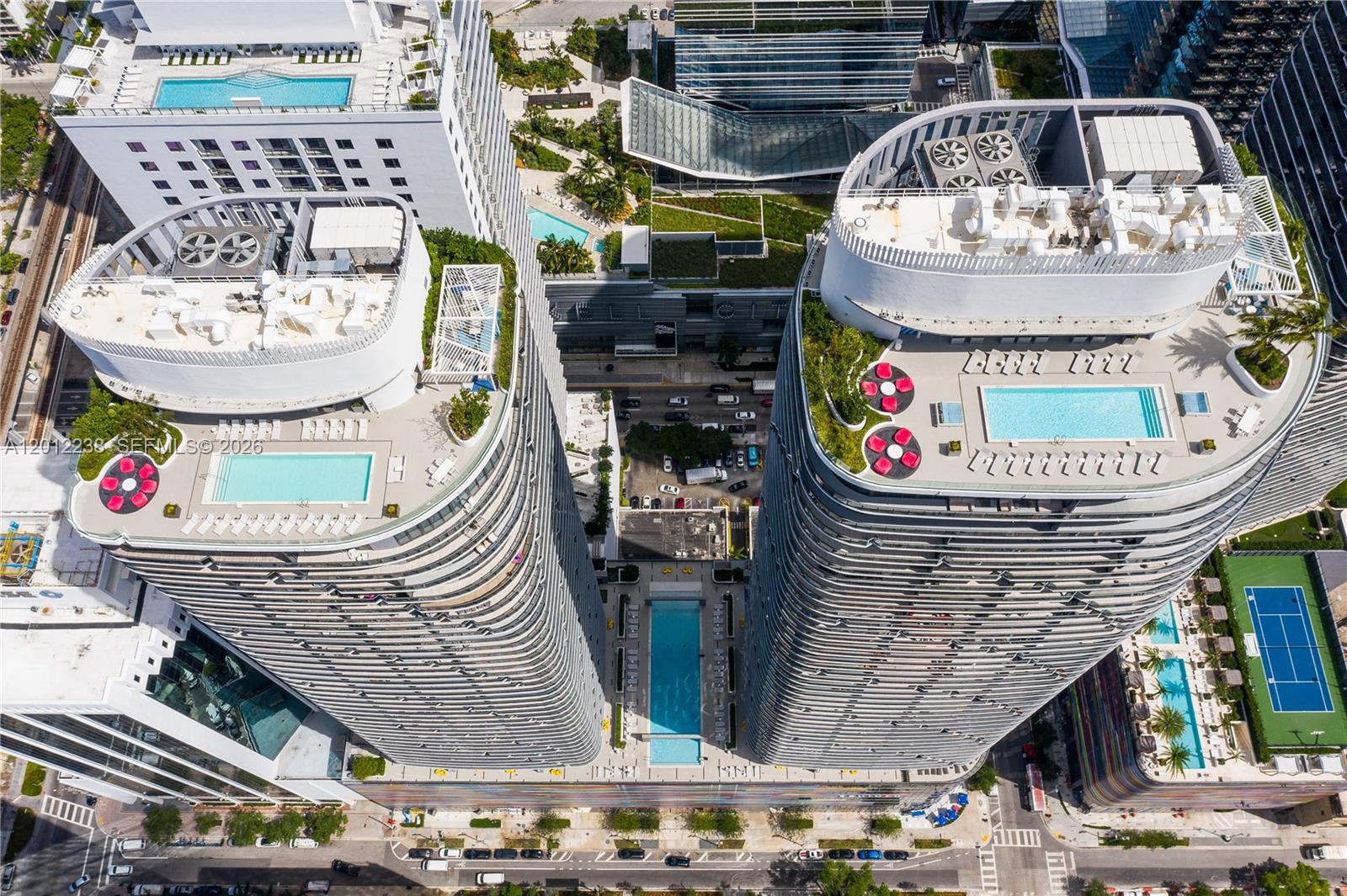 Aerial view of two high-rise residential towers featuring rooftop swimming pools and landscaped terraces — 45 SW 9th St # 1604, Miami FL 33130, MIAMI, FL