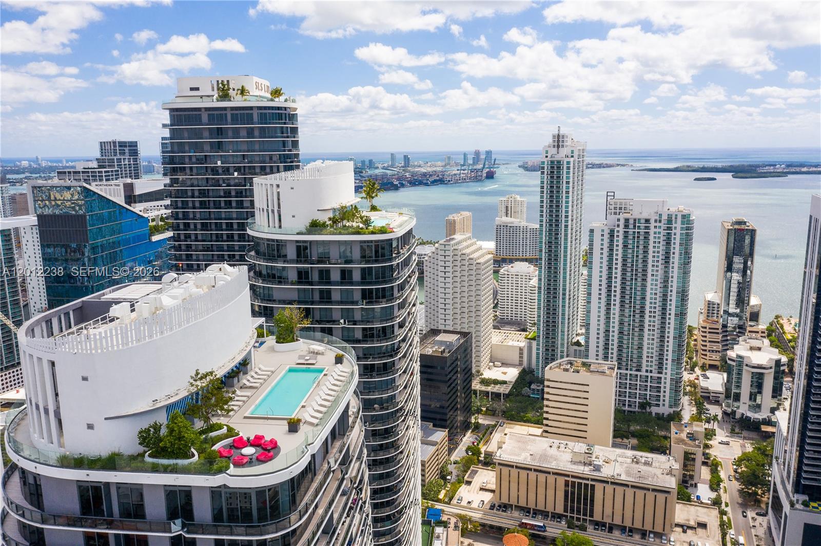 An aerial view shows high-rise apartment buildings with rooftop pools and terraces overlooking the ocean — 45 SW 9th St # 1604, Miami FL 33130, MIAMI, FL