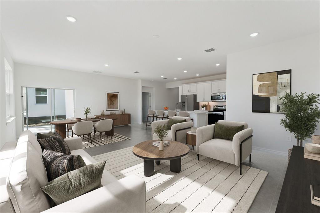An open-concept living and dining area features neutral furniture, a kitchen island, and tile flooring — 4300 DARBY COURT, EUSTIS, FL