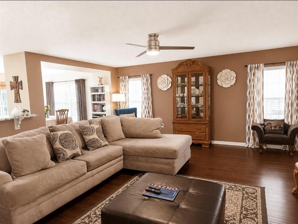A living room features a beige sectional sofa, a leather ottoman, and a wooden cabinet — 32 ANGELA DRIVE, PALM COAST, FL