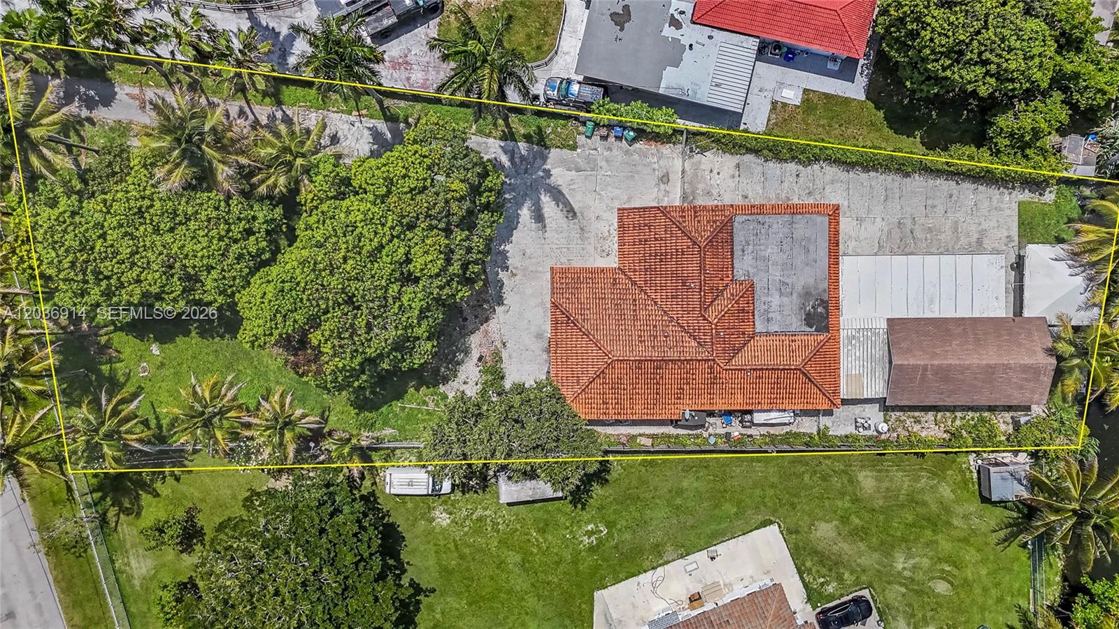 An aerial view shows a house with a red tile roof on a large lot — MIAMI, FL