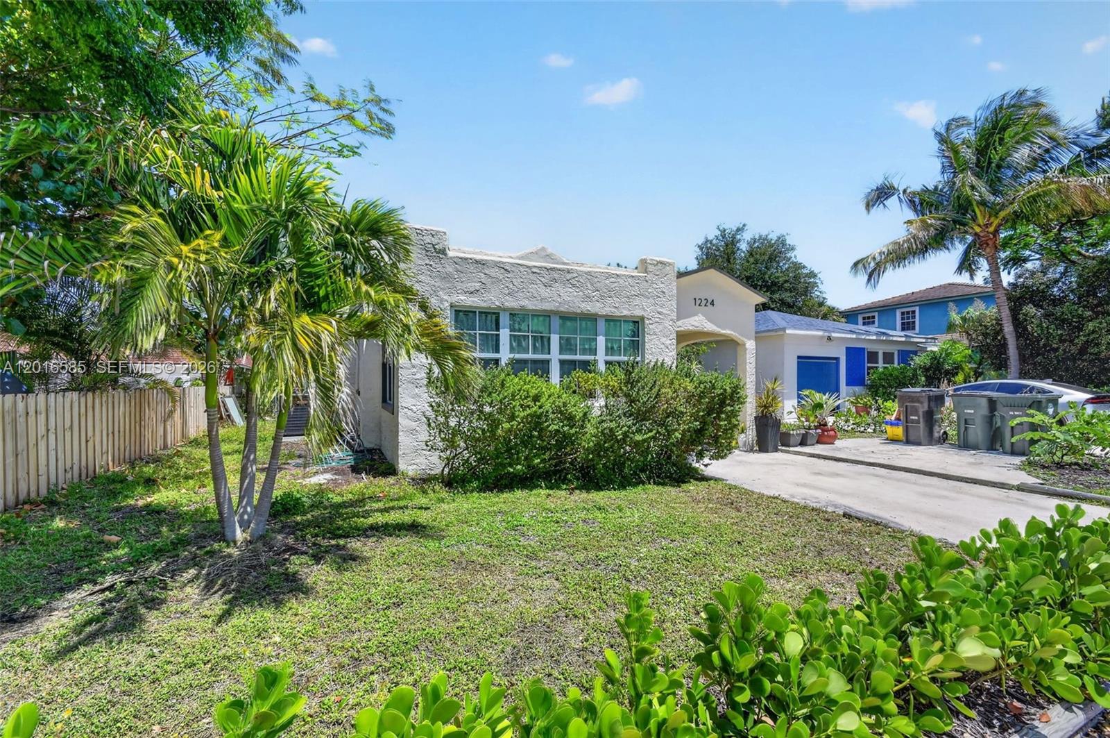 A single-story stucco house with a flat roof and a concrete driveway sits outdoors — 1224 N K St, Lake Worth FL 33460, LAKE WORTH, FL