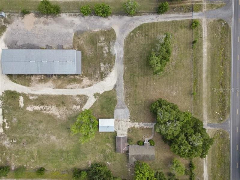 An aerial view shows a house, a detached garage, and a large barn on land — 22429 S US HIGHWAY 441, HIGH SPRINGS, FL