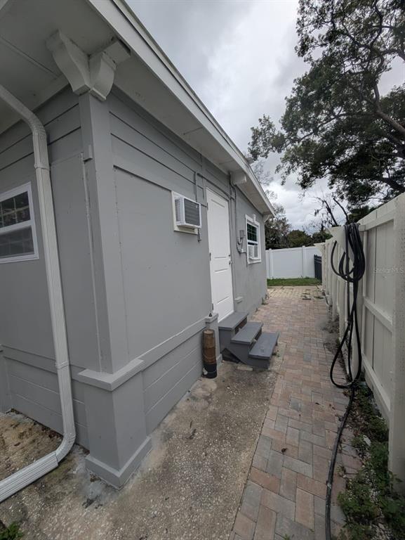 The exterior side of a grey house features a white door, steps, and a paved walkway — 793 ELDRIDGE STREET, ORLANDO, FL