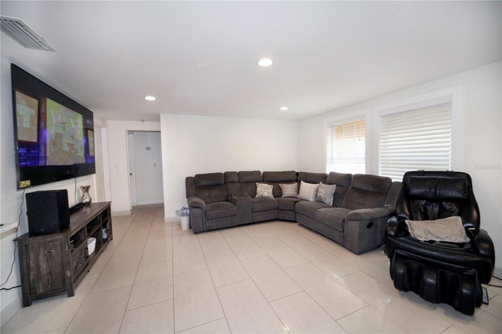 A living room features a large sectional sofa, a black recliner, and a media console — 2653 22ND STREET, SARASOTA, FL