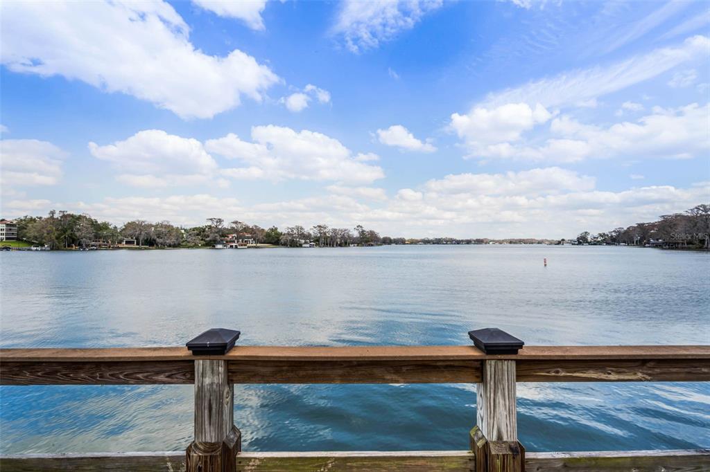A room with wood-look flooring, a gray futon, a coffee table, and a desk chair — 1140 S ORLANDO AVENUE UNIT E11, MAITLAND, FL