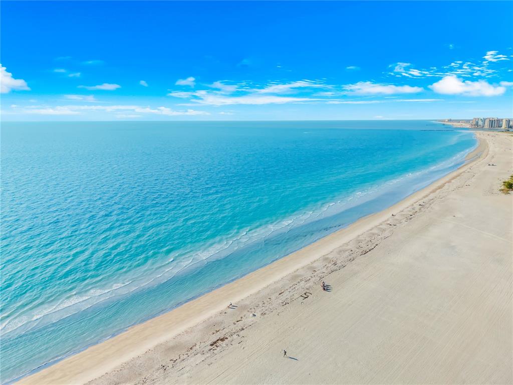 An aerial view of a wide sandy beach meeting the turquoise ocean under a blue sky — 1380 GULF BOULEVARD UNIT PH 5, CLEARWATER BEACH, FL