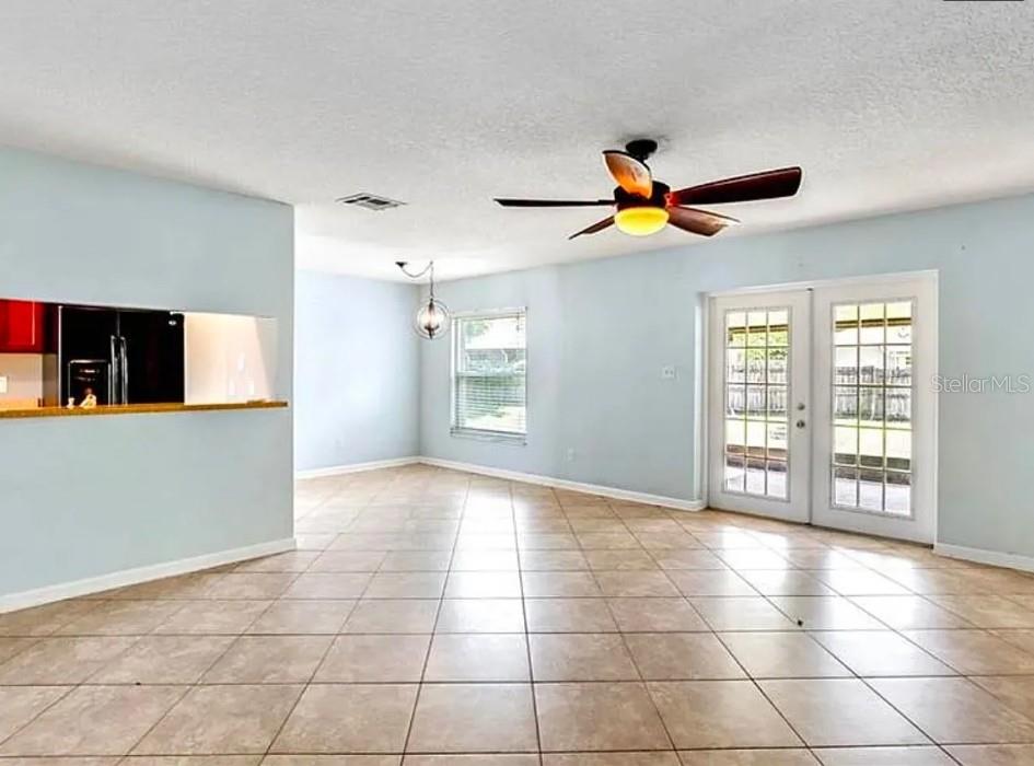 A bright room with light blue walls, tile flooring, a ceiling fan, and French doors — 120 BENT OAK COURT, SANFORD, FL