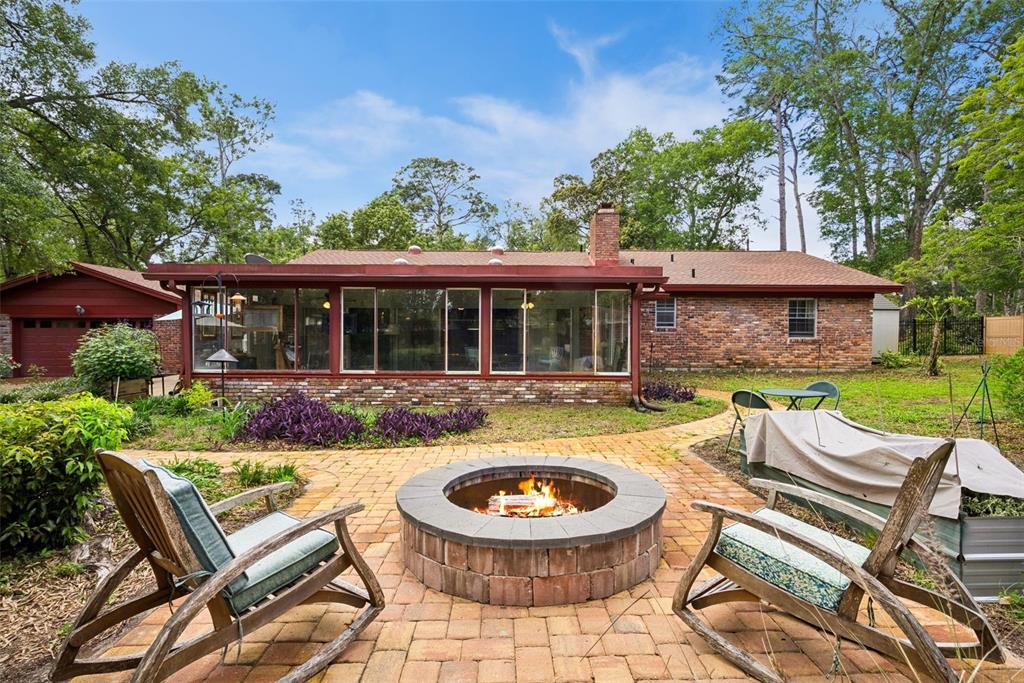 A brick-paved driveway leads to a red-painted house with a garage and sunroom — 295 FRANCES CIRCLE, ALTAMONTE SPRINGS, FL