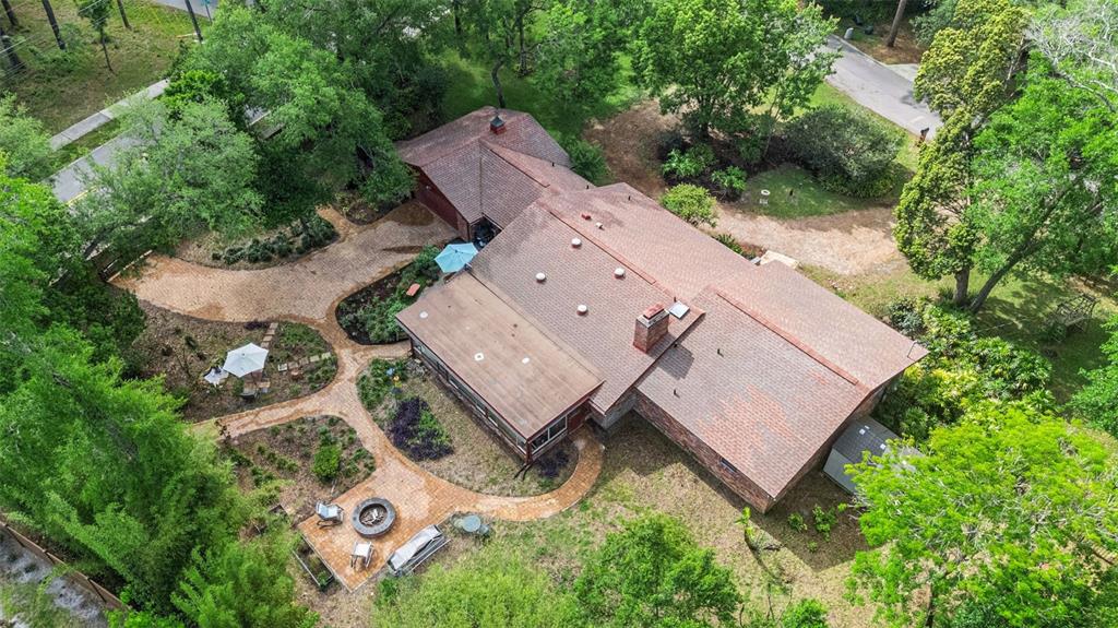 A brick house with a sunroom overlooks a backyard patio featuring a stone fire pit — 295 FRANCES CIRCLE, ALTAMONTE SPRINGS, FL