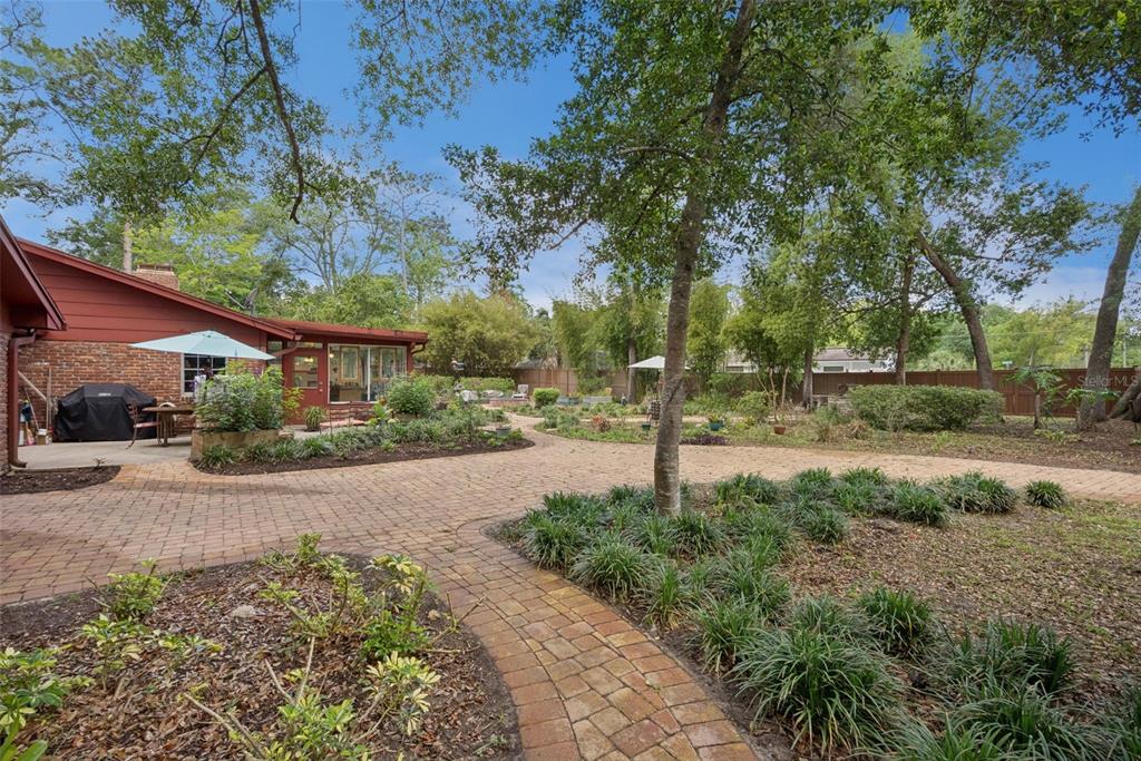 An aerial view shows a brick house with a shingled roof and a paved patio — 295 FRANCES CIRCLE, ALTAMONTE SPRINGS, FL