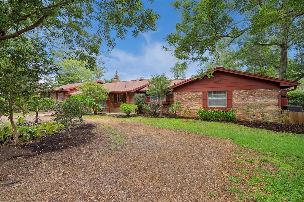 A brick patio with a curved walkway leads to a house with a red exterior — 295 FRANCES CIRCLE, ALTAMONTE SPRINGS, FL
