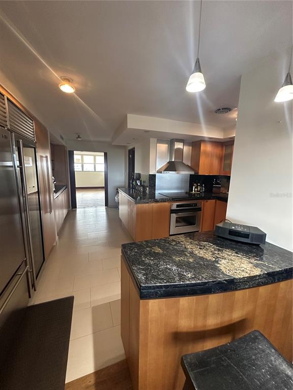 A kitchen features light wood cabinets, dark granite countertops, stainless steel appliances, and pendant lighting — Caoba Street AVENIDA SAN PATRICIO UNIT PH1-PH2, GUAYNABO, PR