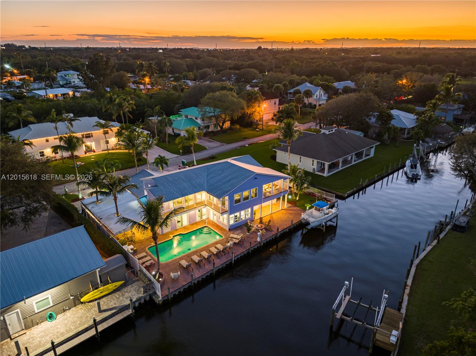 An aerial view shows a blue waterfront house with a pool and private boat dock — 474 Peninsula Dr, Fort Pierce FL 34946, FORT PIERCE, FL