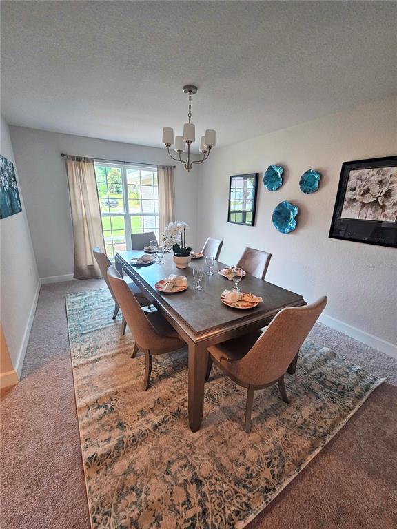A dining room features a rectangular table with six chairs, a chandelier, and wall decor — 133 SW BELLFLOWER DRIVE, LAKE CITY, FL