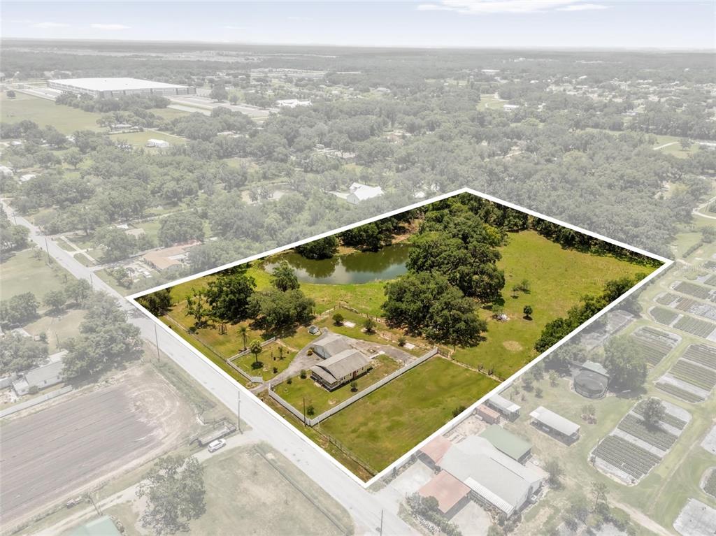 An aerial view shows a house on a large, fenced lot with a pond and trees — 3101 MEDULLA ROAD, PLANT CITY, FL