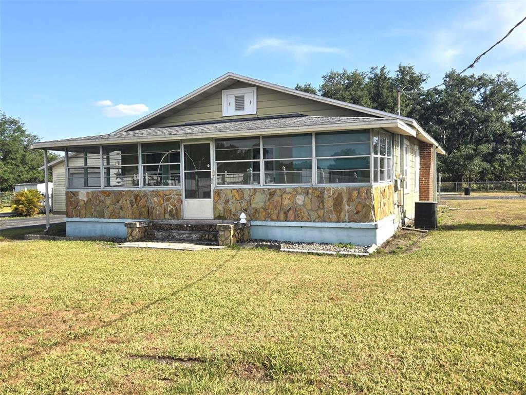 A single-story house with a stone-accented exterior and a large screened-in front porch — 3101 MEDULLA ROAD, PLANT CITY, FL