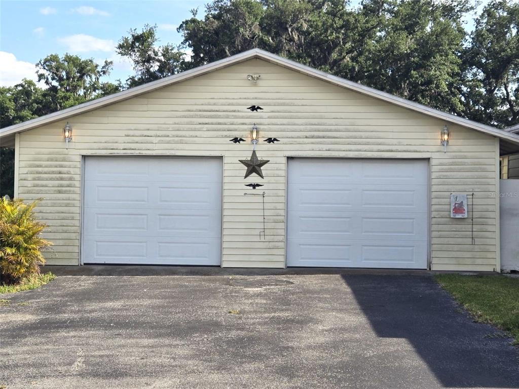 A detached two-car garage with light yellow horizontal siding and a central decorative star — 3101 MEDULLA ROAD, PLANT CITY, FL