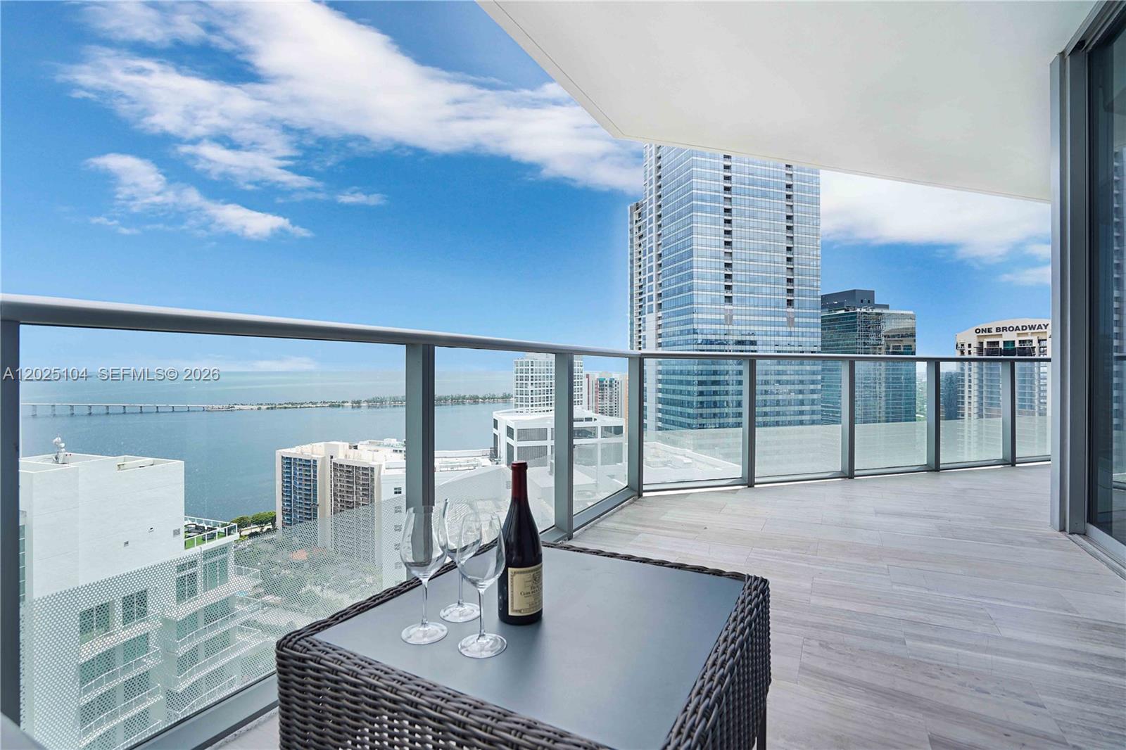 A balcony with a glass railing overlooks a city skyline and a large body of water — 1300 Brickell Bay Dr # 3402, Miami FL 33131, MIAMI, FL