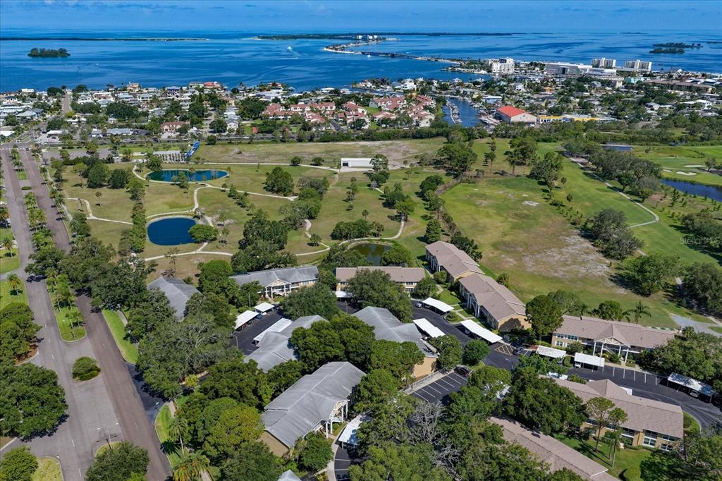 An aerial view shows a residential apartment complex surrounded by green space and small ponds — 2152 GULF VIEW BOULEVARD, DUNEDIN, FL