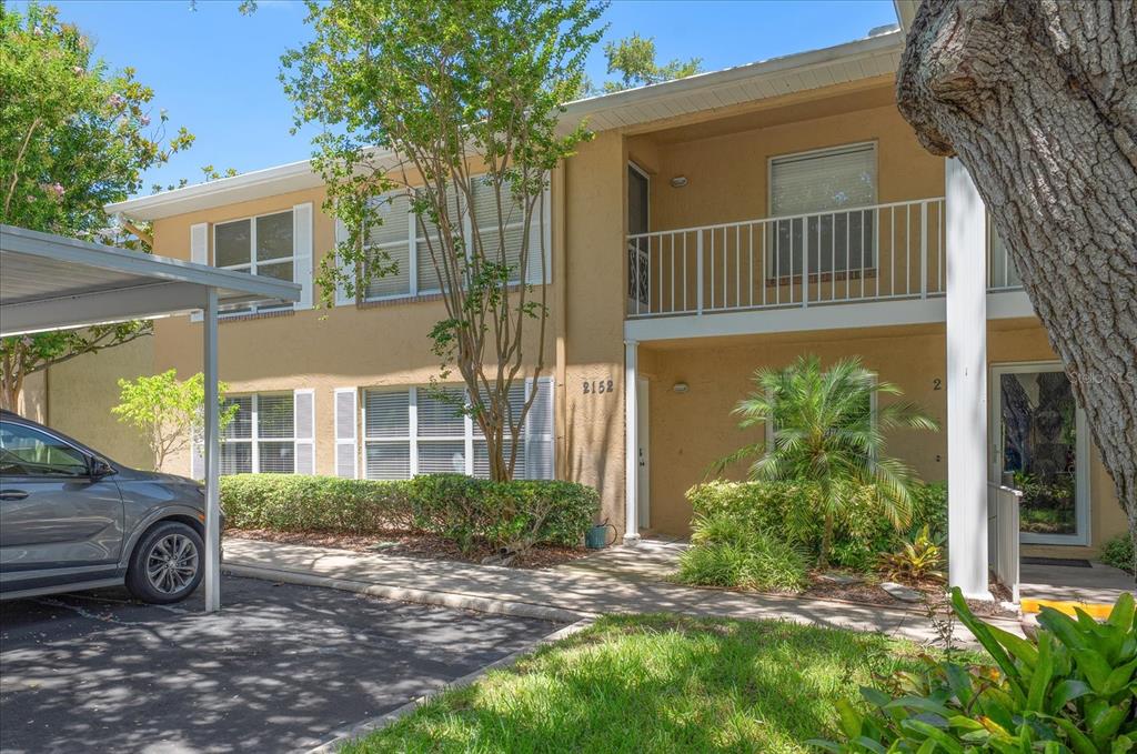 A two-story tan apartment building with a covered parking space and a balcony — 2152 GULF VIEW BOULEVARD, DUNEDIN, FL
