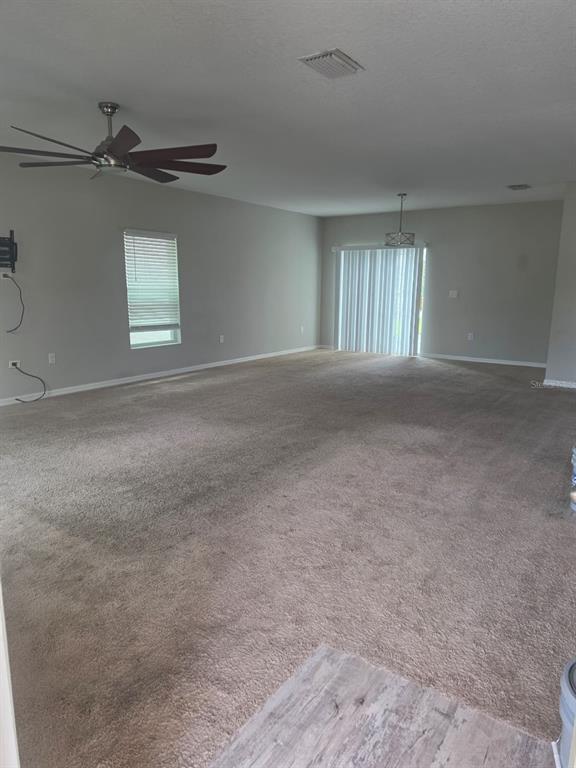 A living room features a beige sofa, a dark coffee table, and a ceiling fan — 13013 UPWARD PLACE, RIVERVIEW, FL