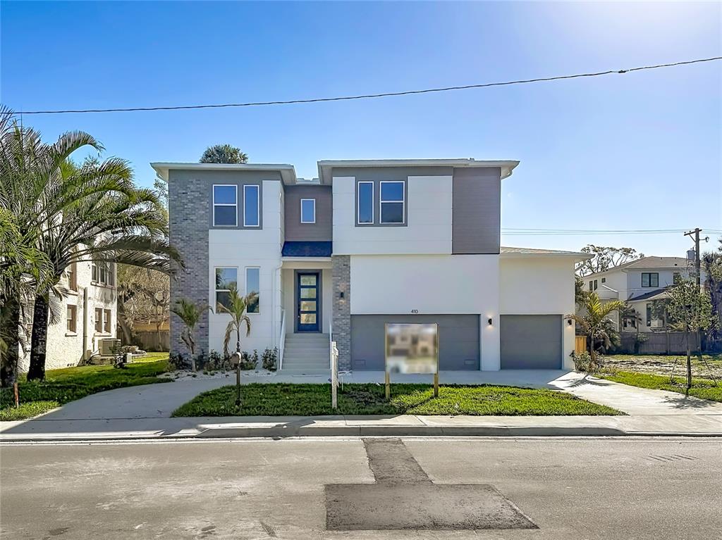 A modern two-story house features a gray brick facade, white stucco, and a three-car garage — 410 S WEST SHORE BOULEVARD, TAMPA, FL