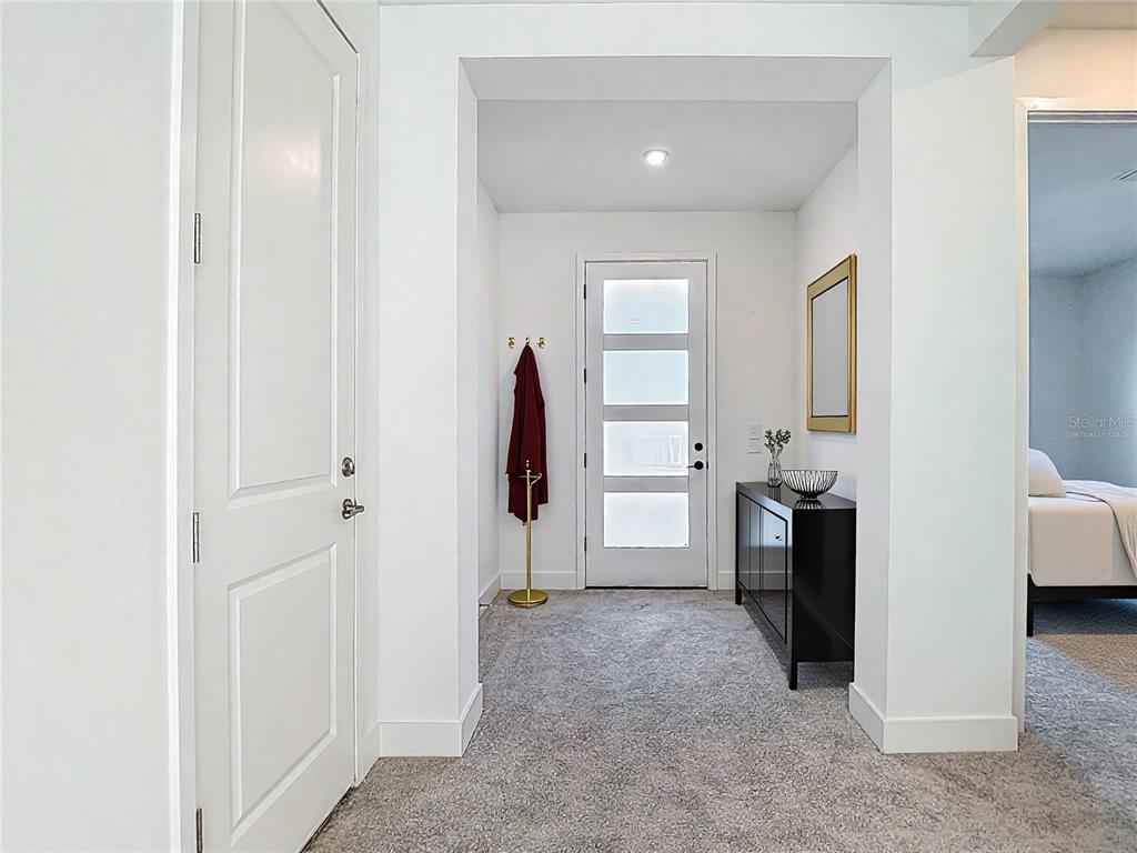 A carpeted entryway features a white front door, a black console table, and a coat rack — 410 S WEST SHORE BOULEVARD, TAMPA, FL