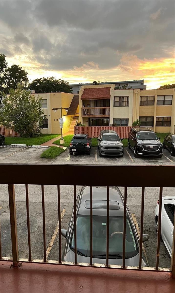 A view from a balcony overlooking a parking lot and a multi-story apartment building — 8875 Fontainebleau Blvd # 203, Miami FL 33172, MIAMI, FL