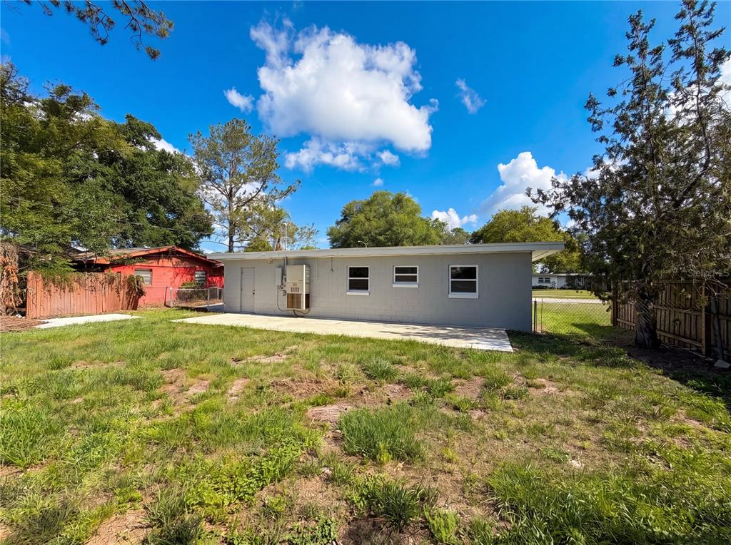 The exterior of a gray concrete block house features a concrete patio and backyard — 459 NOTRE DAME DRIVE, ALTAMONTE SPRINGS, FL