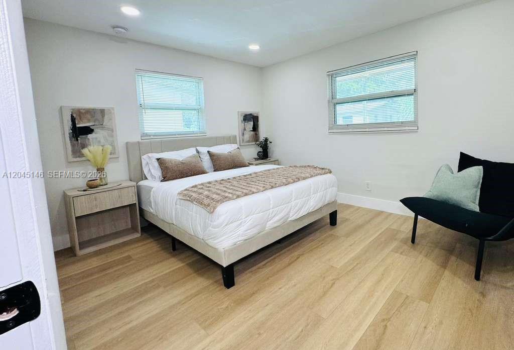 A bedroom features light wood flooring, a bed with a neutral comforter, and two windows — 4708 SW 33rd Ave # 4708, Dania Beach FL 33312, DANIA BEACH, FL