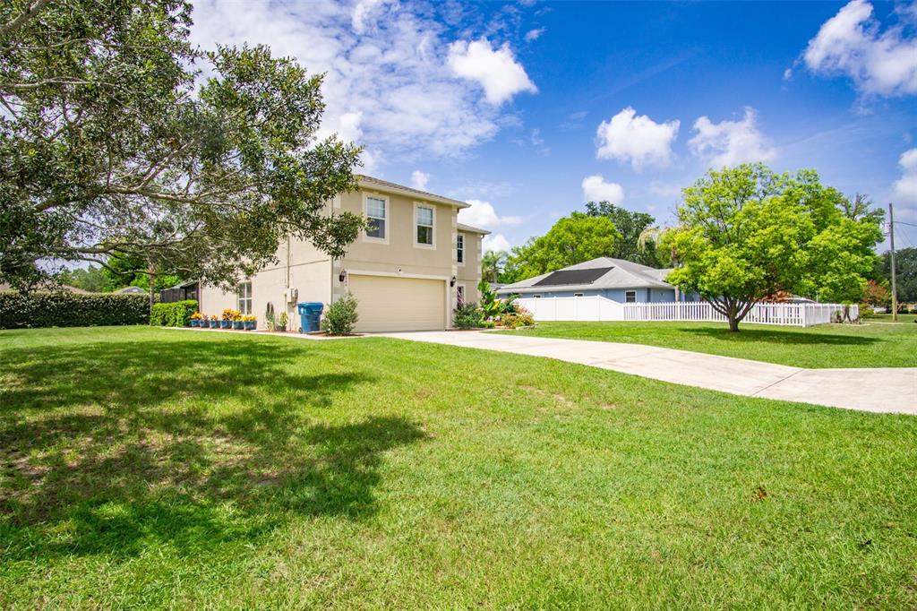 A two-story house with a beige exterior, a two-car garage, and a large front lawn — 10446 AVILA STREET, SPRING HILL, FL