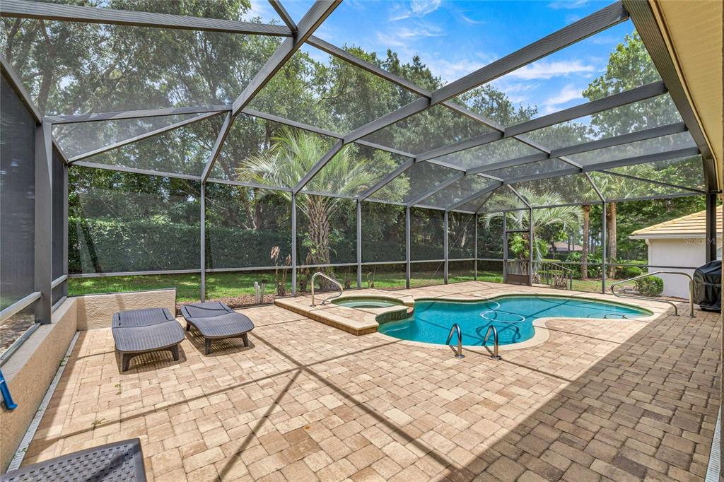 A screened-in patio features a swimming pool, a hot tub, and two lounge chairs — 155 W DOERR PATH, HERNANDO, FL