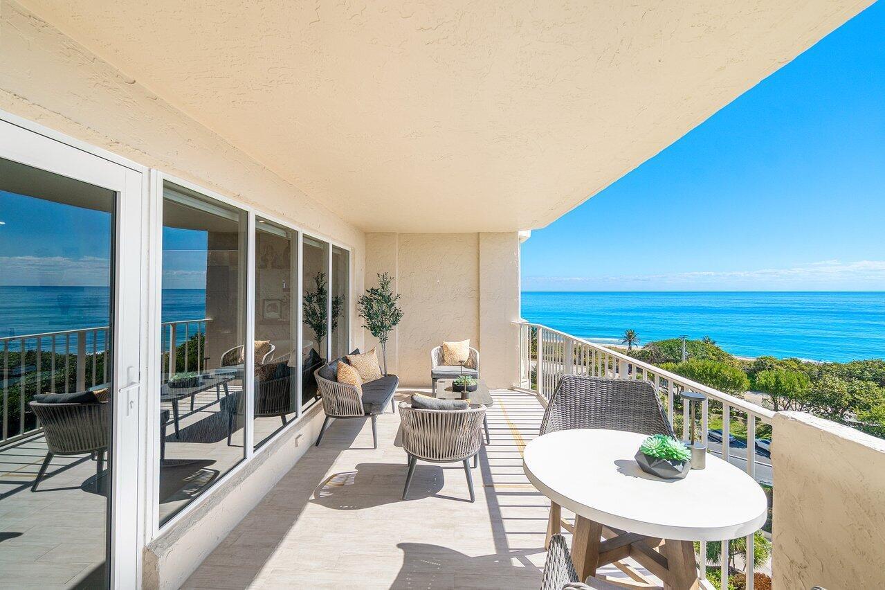 A spacious balcony with outdoor furniture overlooks the ocean and a coastal landscape — 4001 N Ocean Boulevard # 907, Boca Raton FL 33431, BOCA RATON, FL