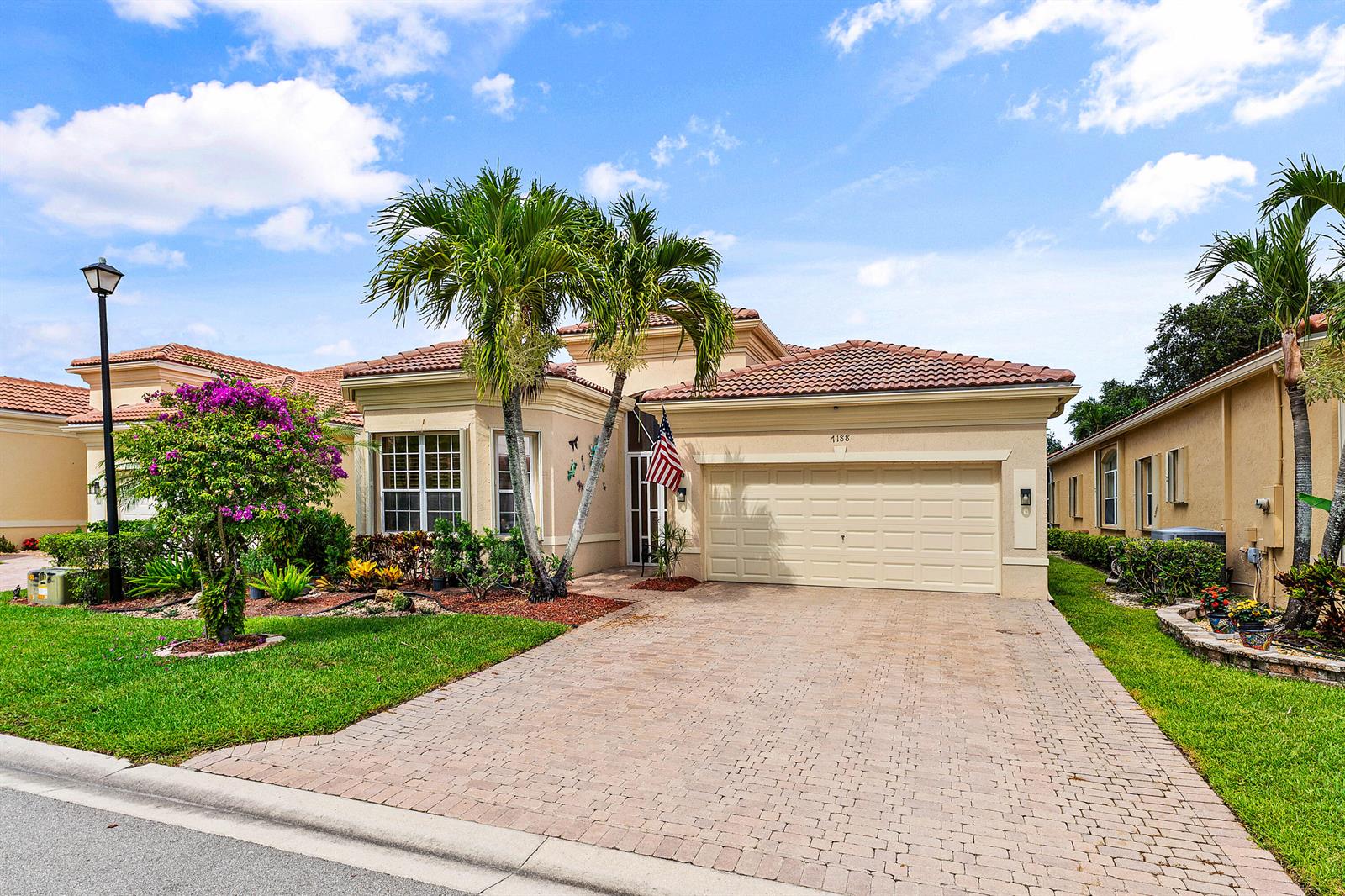A single-story house with a beige stucco exterior, a tiled roof, and a paved driveway — 7188 Demedici Circle, Delray Beach FL 33446, DELRAY BEACH, FL