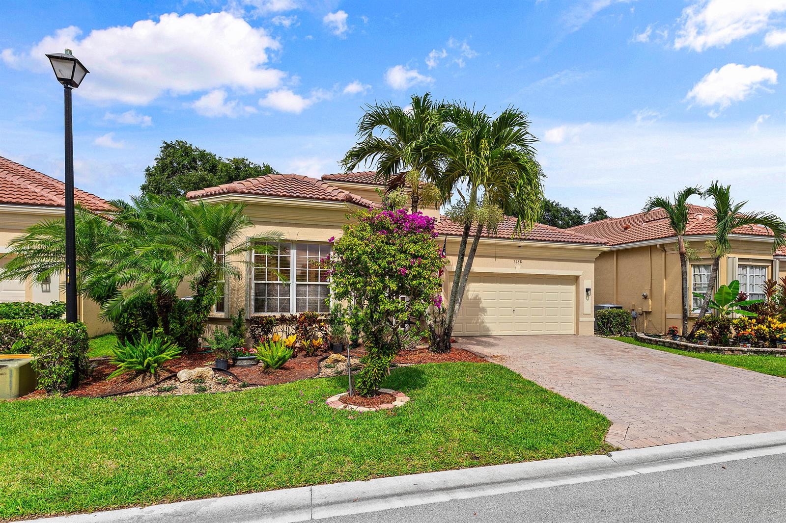 A single-story suburban house with a tile roof, palm trees, and a paved driveway — 7188 Demedici Circle, Delray Beach FL 33446, DELRAY BEACH, FL