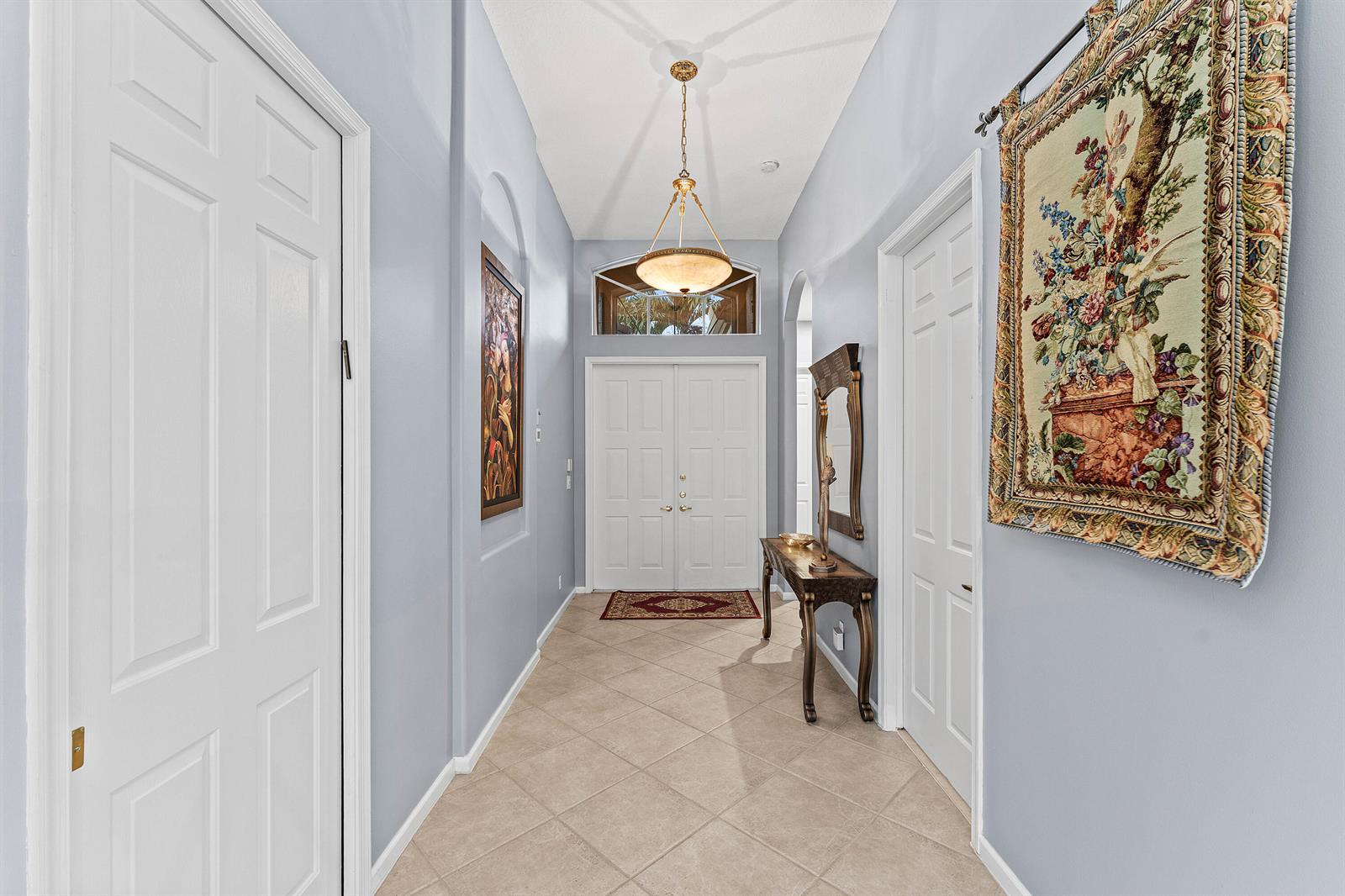 A light blue entryway features a tile floor, double front doors, and a hanging pendant light — 7188 Demedici Circle, Delray Beach FL 33446, DELRAY BEACH, FL