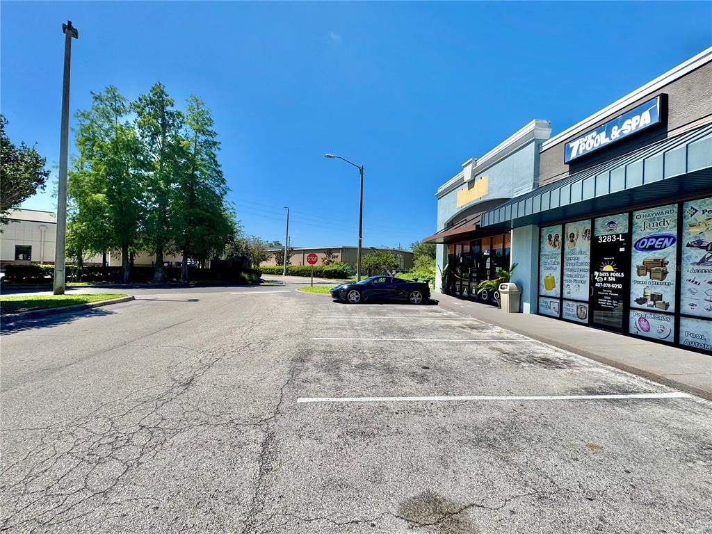 A black sports car is parked in front of a pool and spa supply store — 3283 S JOHN YOUNG PARKWAY, KISSIMMEE, FL