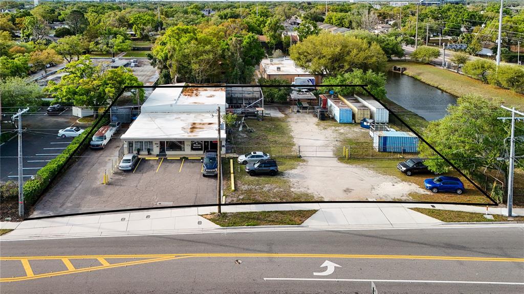 An aerial view shows a commercial building with a parking lot and storage containers — 3440 and 3426 W CYPRESS STREET, TAMPA, FL