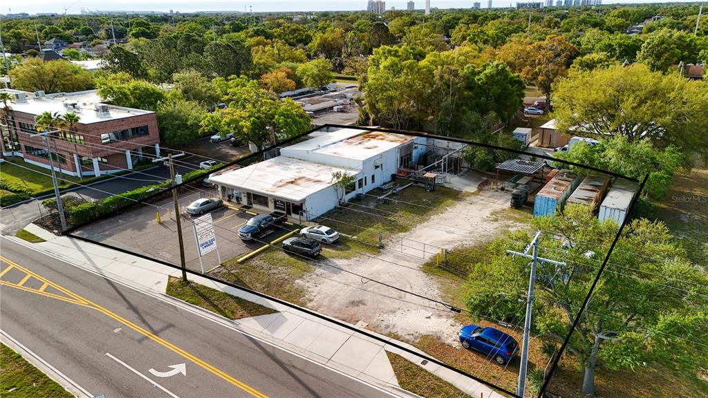 An aerial view shows a commercial building with a parking lot and storage containers — 3440 and 3426 W CYPRESS STREET, TAMPA, FL