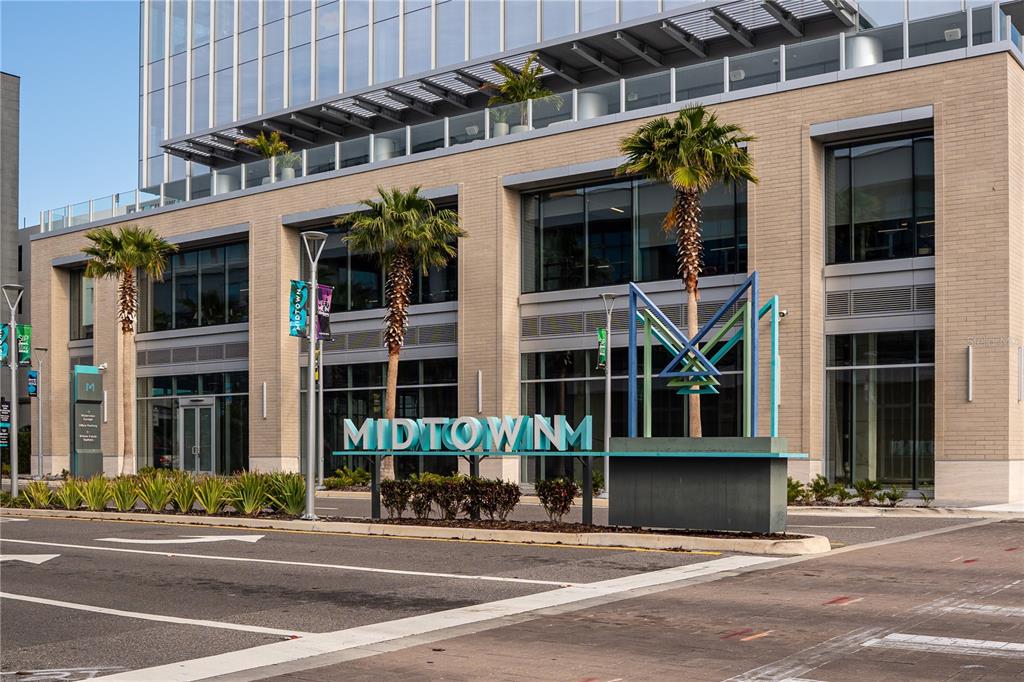 A modern office building exterior features a Midtown sign, palm trees, and a geometric sculpture — 3440 and 3426 W CYPRESS STREET, TAMPA, FL