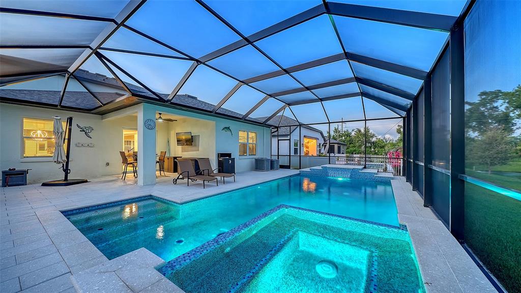 A screened-in patio features a swimming pool, a raised spa, and a covered seating area — 8234 TEA OLIVE TERRACE, PALMETTO, FL